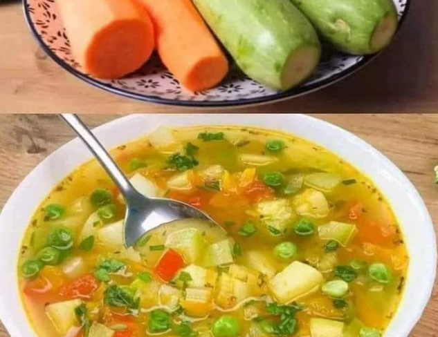 Bowl of hearty vegetable soup with fresh carrots, zucchini, potatoes, and green pea