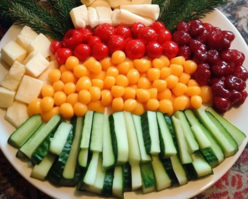 Christmas Tree Snack Platter with green bell peppers, cherry tomatoes, celery, cheese, cucumbers, and baby carrots arranged in a tree shape