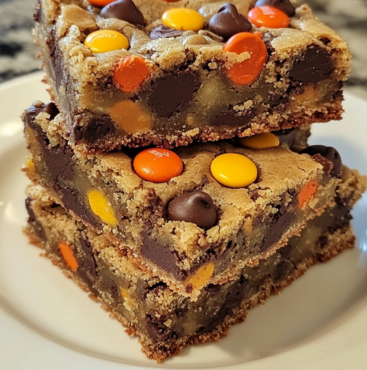 A freshly baked batch of Reese’s Pieces Chocolate Chip Cookie Bars with chocolate and candy toppings, perfect for a sweet treat.