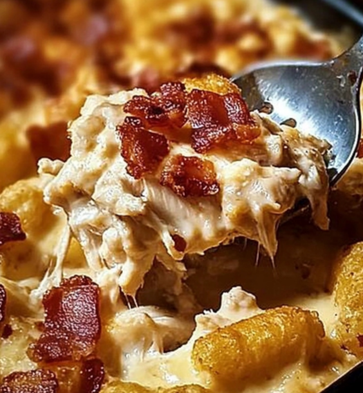 Close-up of Chicken Bacon Ranch Tater Tot Casserole topped with melted cheese and crispy bacon.