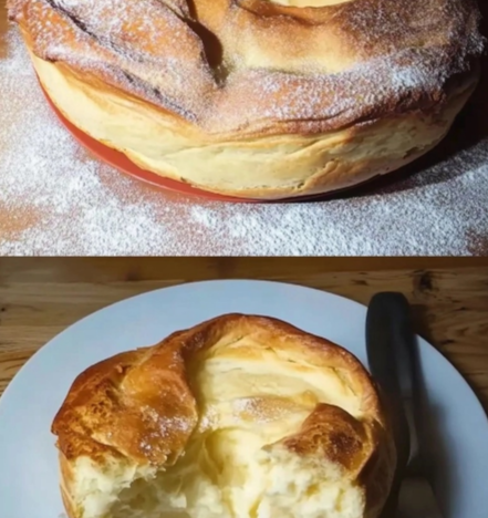 Baked cream puff cake with custard filling dusted with powdered sugar