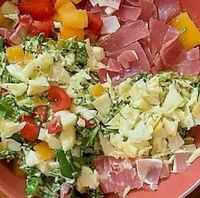 Italian Chopped Salad with lettuce, diced tomatoes, cheese, and ham, served in a yellow bowl for a fresh and colorful dish.