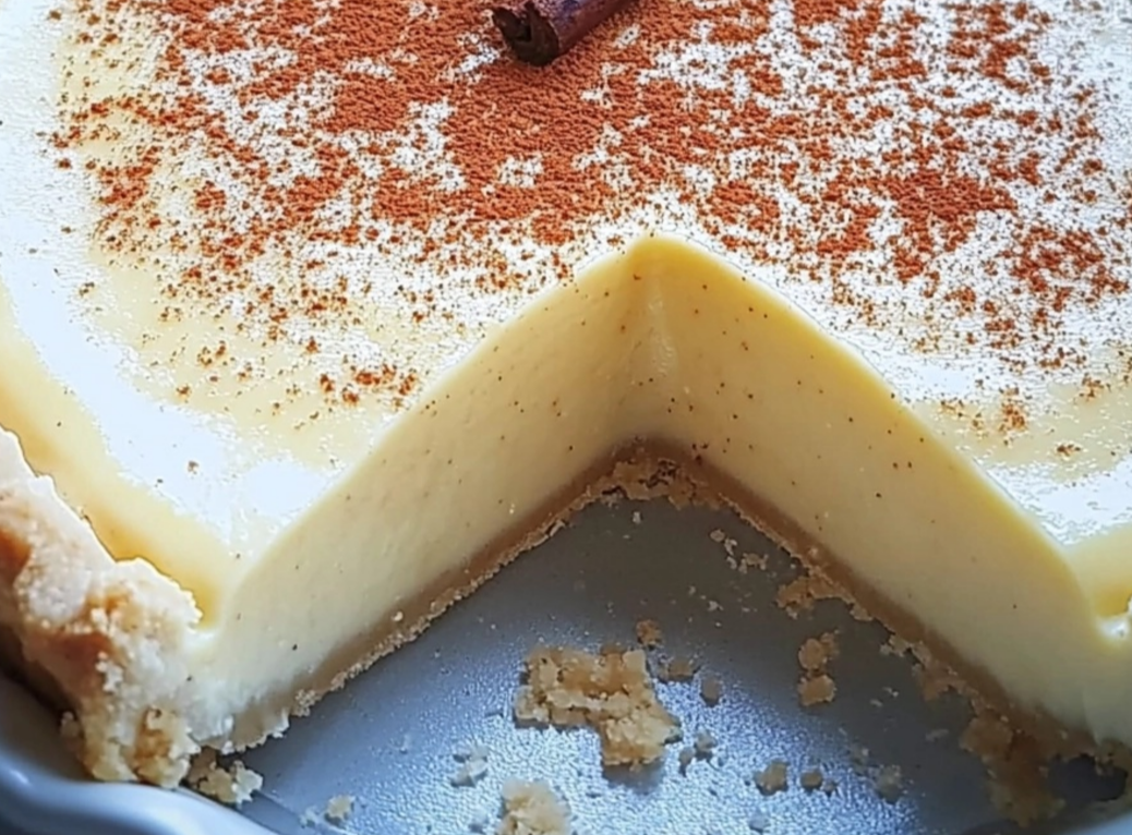 Christmas Eve Cinnamon-Vanilla Creamy Custard Pie with a golden crust and a dusting of cinnamon on top.