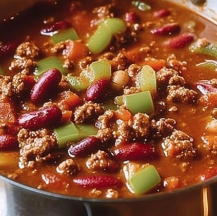 Classic Hearty Chili in a pot with ground beef, kidney beans, diced tomatoes, and fresh vegetables, ready to serve.